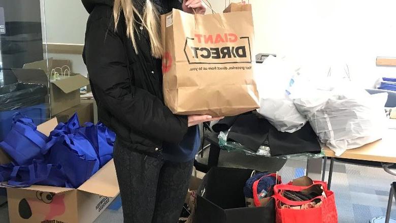 Victoria Stopper holds clothing bag donation 